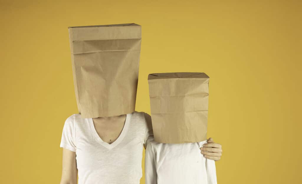 Mother and Daughter in white shirt cover their heads with a paper bag.