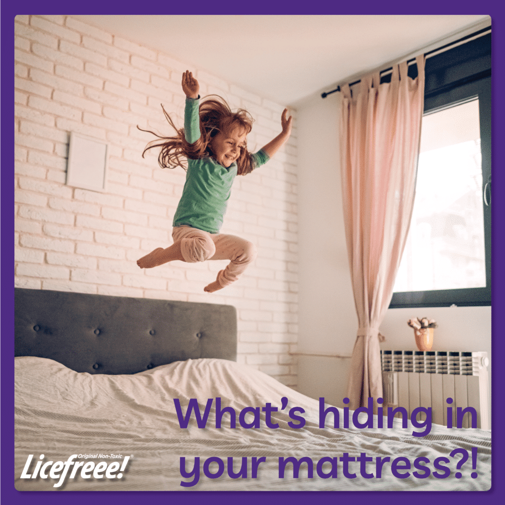 A little blonde girl is jumping high on a mattress.